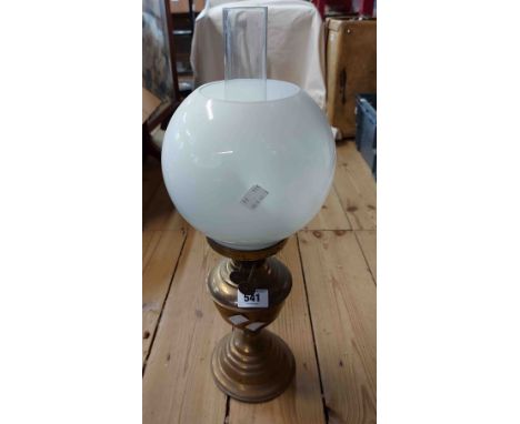 A brass oil lamp with double burner, clear glass chimney and opaque glass globe shade