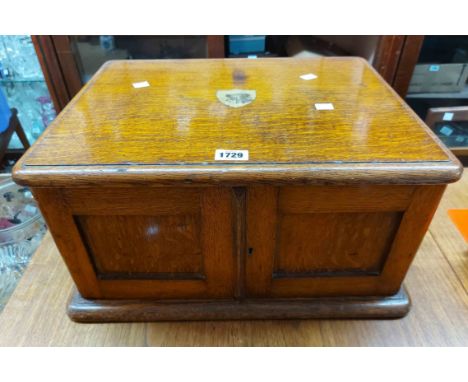 An early 20th Century oak table canteen containing an almost complete suite of Primus silver plated cutlery with feathered bo