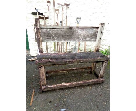 A rustic style oak garden bench of plank form