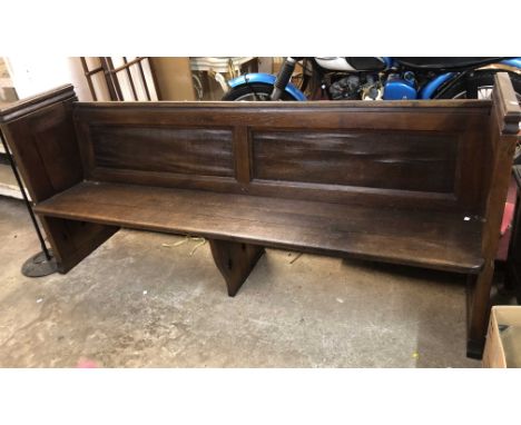 A 2.05m old polished oak pew with panelled back and sides, book trough to back and solid seat