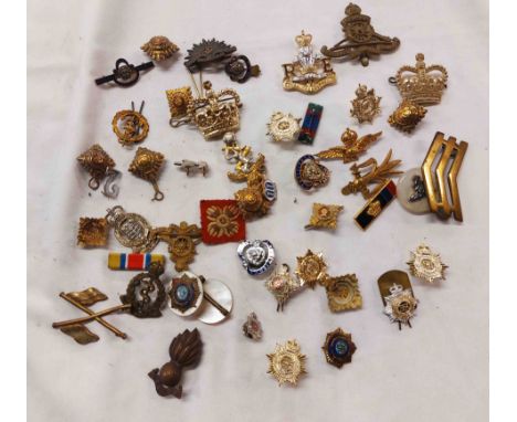A bag containing a large quantity of military cap badges, sweetheart brooches, etc. - various regiments including The Royal A
