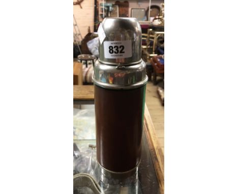 A vintage vacuum flask with glass interior, chrome plated fittings and leather outer