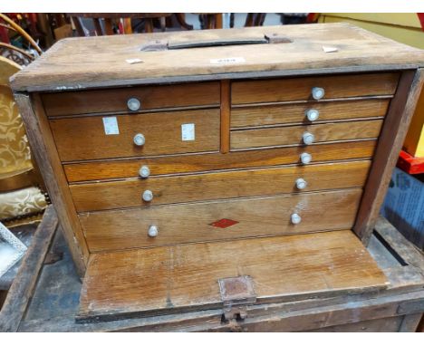 A 46cm vintage Neslein mixed wood engineer's tool chest with an array of eight drawers enclosed by a sliding panel with origi