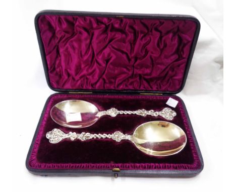 A cased pair of late Victorian silver anointing style spoons with wide bowls and ornate cast stems with engraved initials to 