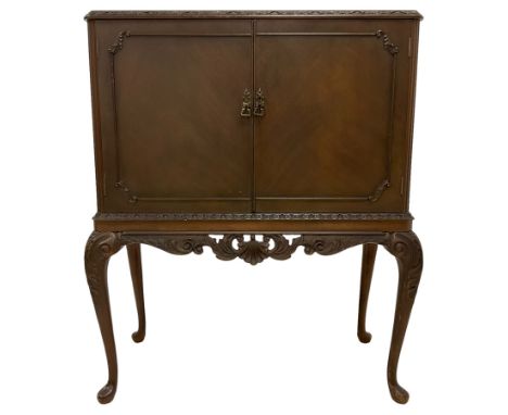 Mid-to-late 20th century mahogany cocktail cabinet, foliate moulded rectangular top with glass inset, two doors enclosing lig