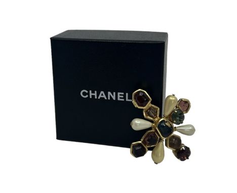 A Chanel brooch in a Byzantine style. Rough cut glass sits in a gold tone cross with two cushion cut crystals with claw setti