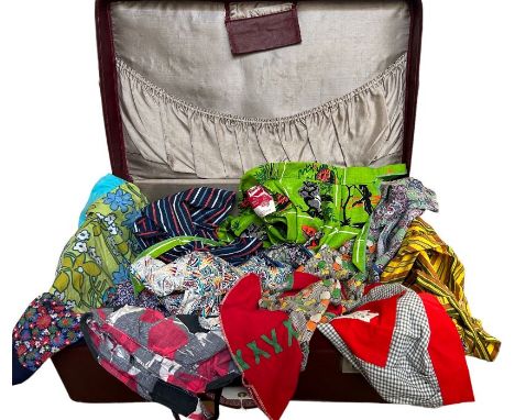 A 1950s suitcase holding a collection of pinnies, 1930s and later, including a 1950s novelty print Australian souvenir, tags 