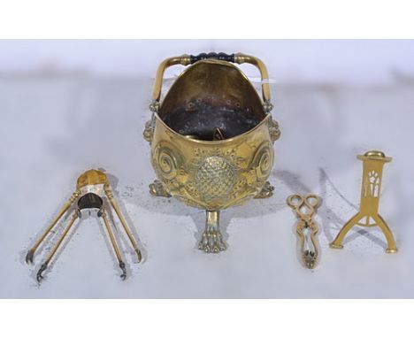 Edwardian brass helmet shape coal scuttle, cast lion masks and lion paw feet, height 37cm, a brass fender, fire irons etc.