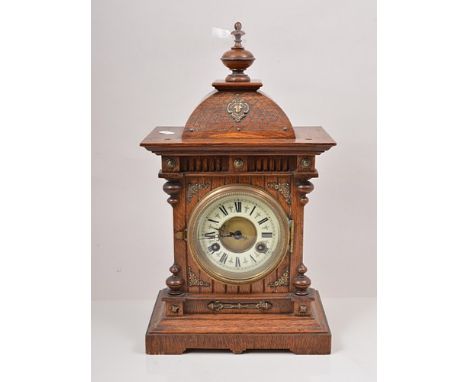 Oak mantel clock, with brass appliques, ivorine chapter ring, movement striking on a gong, 43cm overall.