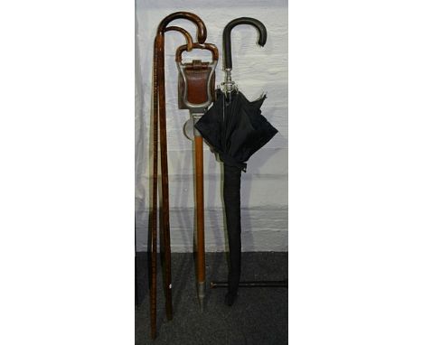 Shooting stick by Howell, London, two bamboo walking sticks, a carved wood cane and an umbrella.