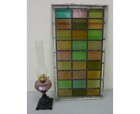 Early 20th century oil lamp and a stained glass panel 77cm x 43cm 