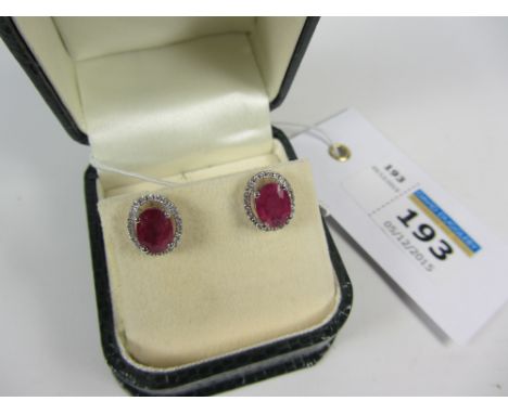 Pair of oval ruby and diamond halo set ear-rings stamped 750