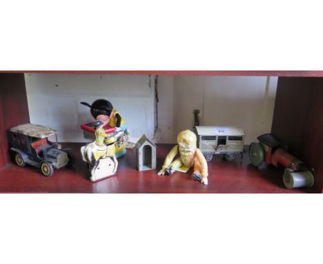 A black tin plate model of a vintage car, a xylophone playing Mickey Mouse puppet, and other tin plate toys