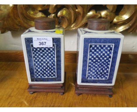 A pair of Chinese blue and white square jars, with chequer and square scroll decorated sides, with turned wood lids and hardw
