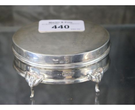 An oval silver trinket box on four legs