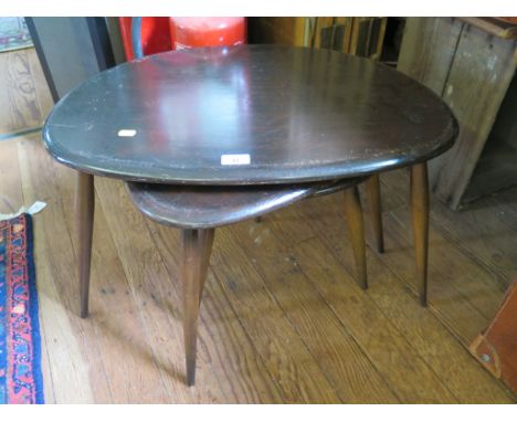 A nest of three Ercol dark stained beech pebble tables, largest 65cm wide, labelled