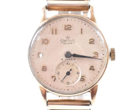A hallmarked 9ct yellow gold cased Smith De Luxe Dennison wristwatch. The watch having a circular white dial with gold tone A