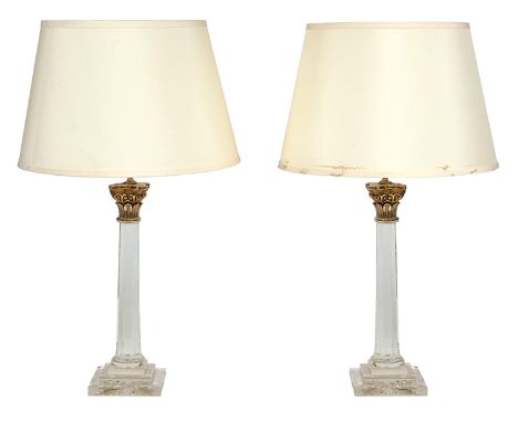 A PAIR OF GILT METAL MOUNTED GLASS COLUMNAR LAMPS

each with a cream silk shade (water marks to shades), each lamp base 44.5c