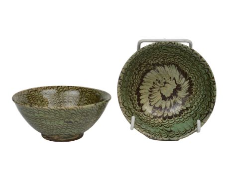 TWO CHINESE GREEN-GLAZED MARBLED CERAMIC BOWLS

one of a more olive hue, the lovely swirling pattern continuing to the interi