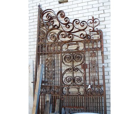 A LARGE PAIR OF WROUGHT IRON GATES
with linear and scroll decoration, one inset with a secondary smaller gate, 325 x 156cm