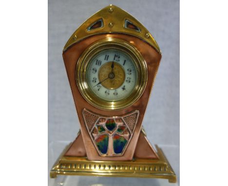 AN ARTS &amp; CRAFTS BRASS AND COPPER CASED CLOCK with inset enamel panel below a stylised tree, 16cm high