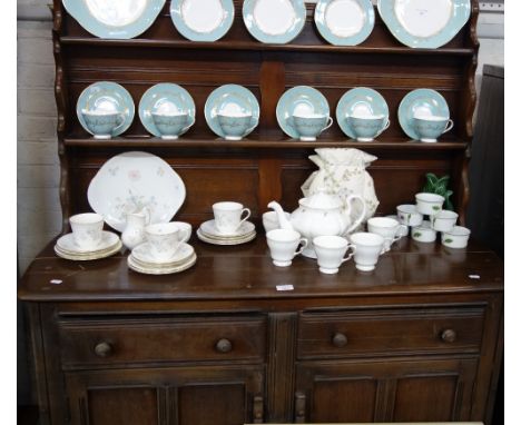 ERCOL; A DARK STAINED OAK SIDEBOARD, with plate rack, 124cm wide a similar stained dining table and four stained stick back c