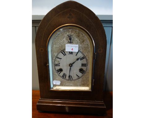 AN EDWARDIAN MAHOGANY CASED BRACKET CLOCK, of arched form with bevelled glass and silvered dial, striking on a gong