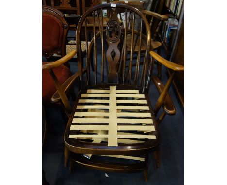 ERCOL: A pair of dark stained Prince of Wales Feathers type armchairs (no cushions)