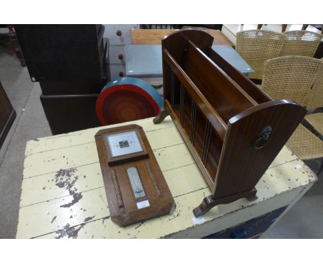 An oak aneroid barometer and a mahogany magazine rack 