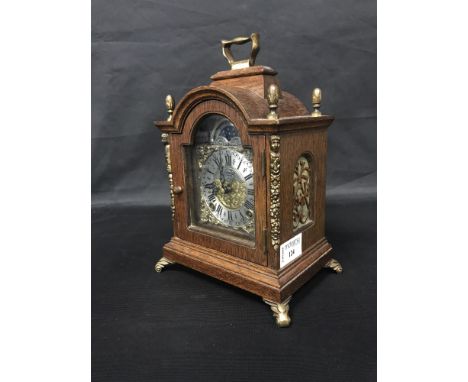 REPRODUCTION BRACKET CLOCK OF 18TH CENTURY DESIGN with moon phase, front widing keyholes, brass swing handle, on four scrolli