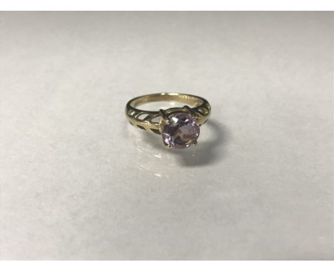 PURPLE GEM SET RING the round purple stone 8mm in diameter, on openwork shoulders, in nine carat gold, size N, 3.2g