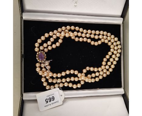 A triple strand simulated pearl necklace set with large 9ct gold amethyst and seed pearl clasp (one pearl missing)