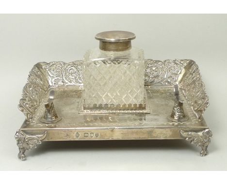 A Victorian silver desk stand of rectangular section, outswept to three sides with pierced and engraved decoration of cherubs