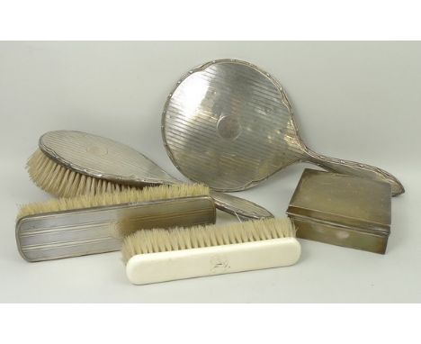 A silver dressing table hand mirror and matching clothes brush with engine turned decoration, Birmingham 1915, a silver cloth