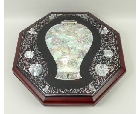 A Korean lacquer octagonal supper set, opening to reveal nine segments, the lid mother of pearl inlaid with a central vase in