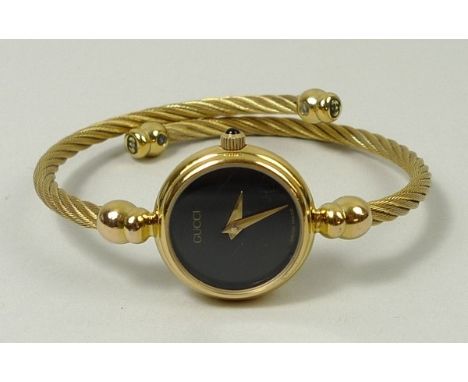 A Gucci bangle wristwatch, the circular black face with pointed hands, marked to back 2700 2 L, number 0257366, boxed. 