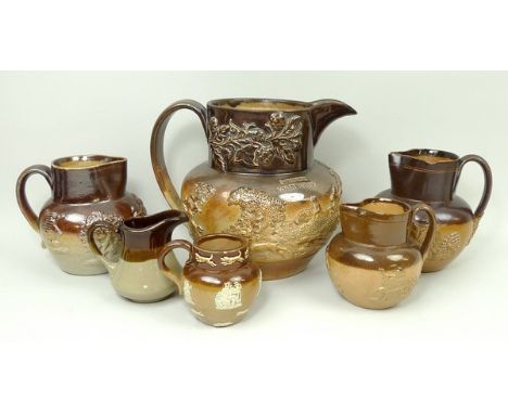 A group of stoneware two tone harvest jugs, the largest moulded with a hunting scene beneath a band of hops, impressed I.Thor
