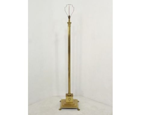 A brass standard lamp, 20th century, of fluted, Corinthian column form, raised on a stepped, square base and lion's paw feet,