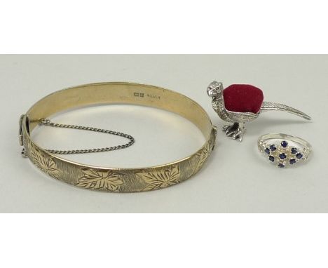 A gold plate on silver bangle, 0.90toz, a silver and sapphire set dress ring, size N, and a silver pin cushion in the form of