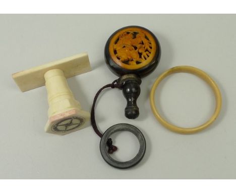 A Japanese horn snuff bottle inset with a bone dragon pierced plaque, fitted with a ring attachment, 7cm high, a bone stamp e
