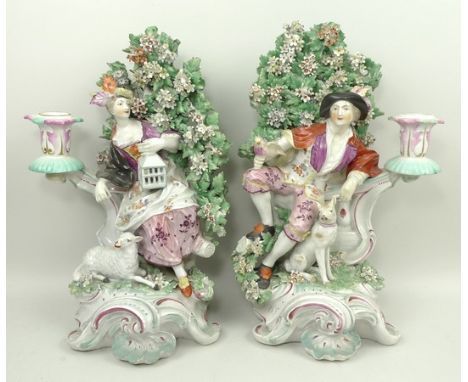 A pair of Derby porcelain figural candlesticks, late 18th century, modelled as a gallant with hound and holding a dove, and a