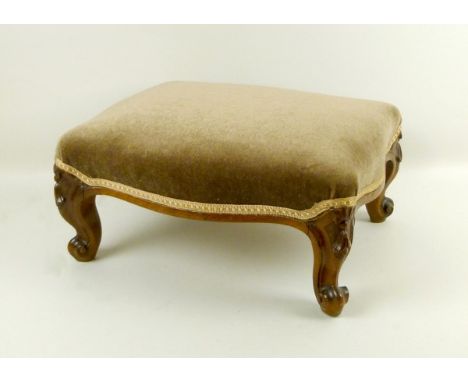 A late 19th century French fruitwood footstool with short cabriole legs carved with scroll feet, upholstered with light brown