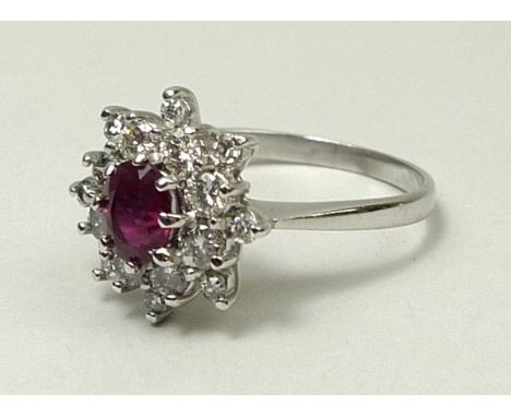 An 18ct white gold, ruby and diamond double cluster ring, ruby 1ct, diamonds approximately 0.4ct, size O, 4.1g.