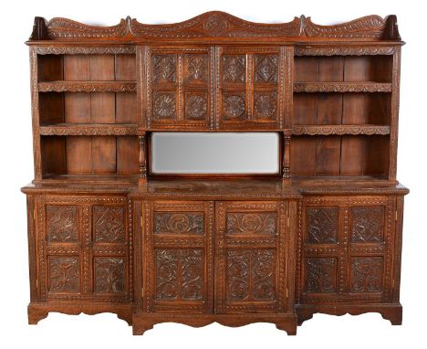 An carved oak breakfront side cabinet, late 19th/20th Century the superstructure with leaf carved top above a pair of leaf ca