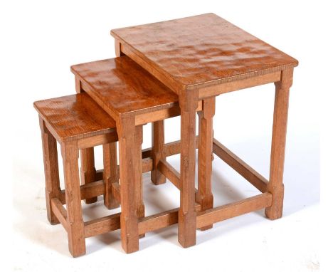 Robert 'Mouseman' Thompson of Kilburn: a nest of three oak occasional tables, each on octagonal legs and with carved mouse mo
