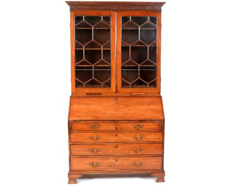 A George III mahogany bureau bookcase, the upper section with dentil cornice above a blind fret frieze, a pair of glazed astr