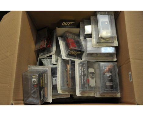 A box containing numerous boxed sealed scale model 007 James Bond cars and magazines.