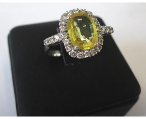 YELLOW SAPPHIRE AND DIAMOND CLUSTER RING cushion cut yellow sapphire surrounded by twenty-six diamonds between bifurcated sho