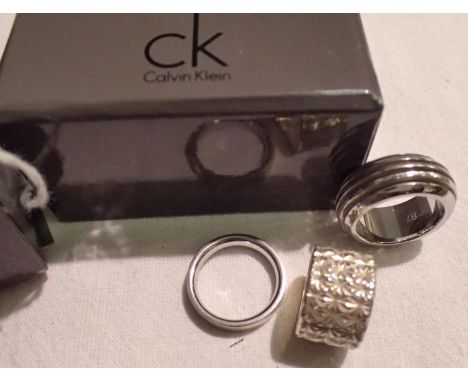 Calvin Klein wide band ring, size N, a solid silver band, size K and a further ring, size L, in a CK box. P&amp;P Group 1 (£1