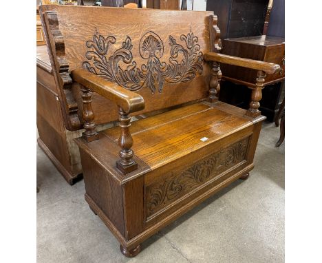A carved oak monks bench 